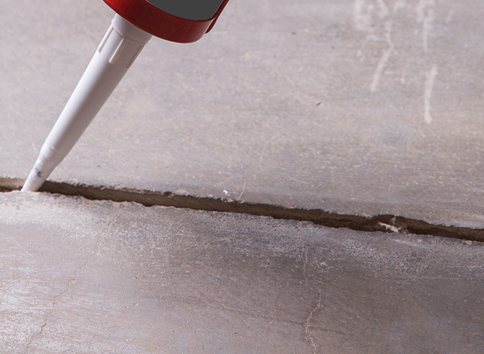 Polyuretanový tmel používaný k opravě praskliny v betonové podlaze.